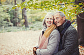 Smiling senior couple hugging in autumn park