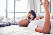 Smiling couple laying and relaxing on bed