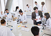 Professor and college students using microscopes