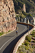 Male triathlete cyclist cycling uphill