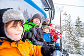 Portrait family riding ski lift