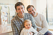 Portrait smiling male gay parents with baby son