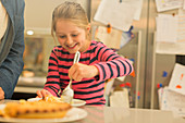 Smiling, eager girl serving pie