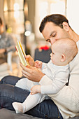 Father reading book to baby son