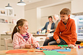 Brother and sister doing crafts at table