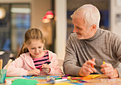 Father and daughter bonding, doing crafts at table