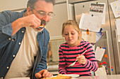 Father and daughter eating pie
