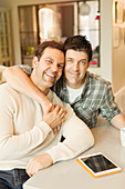 Portrait male gay couple with tablet hugging