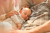 Tired sleeping baby son napping with father