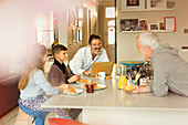 Male gay parents and children enjoying breakfast
