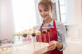 Smiling female caterer baking cake pops