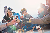 Skier friends toasting cocktail glasses apres-ski