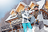 Snowboarder couple carrying snowboards