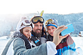 Skier friends taking selfie with camera phone