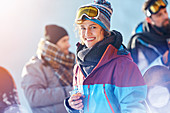 Portrait smiling female skier drinking cocktail
