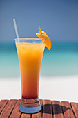 Orange cocktail on ocean beach