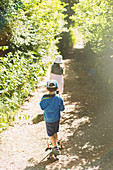 Children walking on tree lined park path