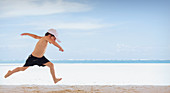 Playful boy running on beach