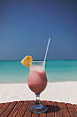 Pink cocktail on ocean beach