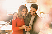 Affectionate couple using cell phone