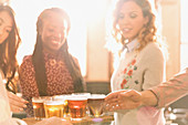 Women friends sampling beer at microbrewery bar