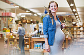 Smiling pregnant woman shopping