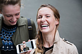 Laughing young women showing selfie