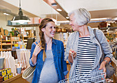 Smiling pregnant woman and mother shopping