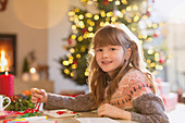 Smiling girl making Christmas decorations