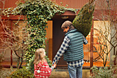 Father and daughter carrying Christmas tree