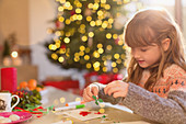 Girl making Christmas decorations at table