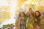 Friends hugging at autumn canal