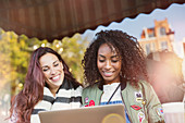 Young women friends using laptop