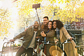 Smiling friends with bicycle taking selfie