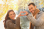Young couple forming heart-shape with hands