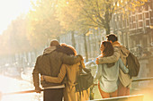 Young couples hugging on bridge over autumn canal