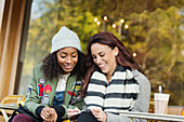 Young women friends writing postcard