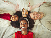 Overhead Multi-ethnic young family laying on bed