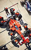 Overhead pit crew working on formula one race car
