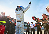 Formula one racing team and driver cheering