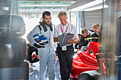 Manager and formula one race car driver talking