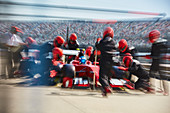 Pit crew replacing tires on formula one race car