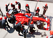 Overhead pit crew replacing tires on race car