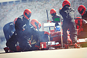 Pit crew replacing tires on formula one race car