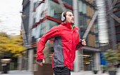 Man running with headphones past building