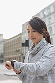 Female runner checking smart watch on street