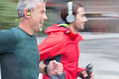 Male runners with headphones running