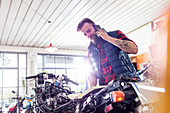 Motorcycle mechanic talking on cell phone
