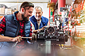 Male motorcycle mechanics repairing engine