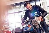 Male motorcycle mechanic wiping motorcycle